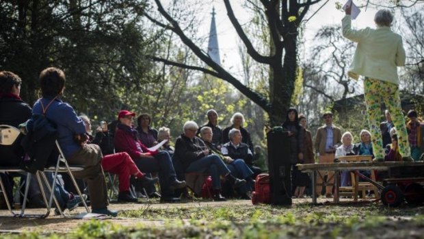 Activists listen to the recital of a poem as they attend the opening ceremony of a lesbian-only cemetery in Berlin.