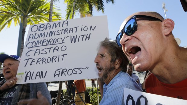 Anti-Castro activists Osvaldo Hernandez, right, and Miguel Saavedra, second from right, chant anti-Obama slogans in the Little Havana area of Miami.