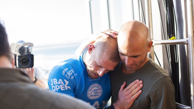 Glad you're all right: Kelly Slater embraces fellow world champion Mick Fanning.