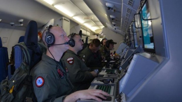 The search area widens ... A crew members on board a US Navy P-8A Poseidon at their workstations while assisting in search and rescue operations for Malaysia Airlines Flight MH370.