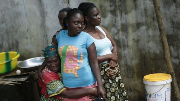 Ethel Konneh, left, is consoled by her daughters outside the Island Clinic Ebola isolation and treatment centre, after she learned her other daughter Rose Johnson passed away from Ebola in Monrovia, Liberia. 