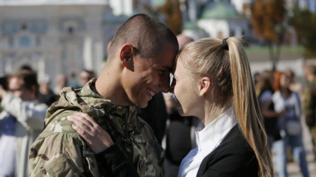Brief respite ... A fighter from the Azov volunteer battalion talks to his girlfriend as he arrives on rotation from the front line in Kiev, Ukraine.