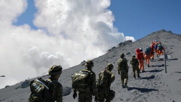 Japan's Self Defense Force soldiers and rescue workers search for survivors on the ash-covered top of Mount Ontake.
