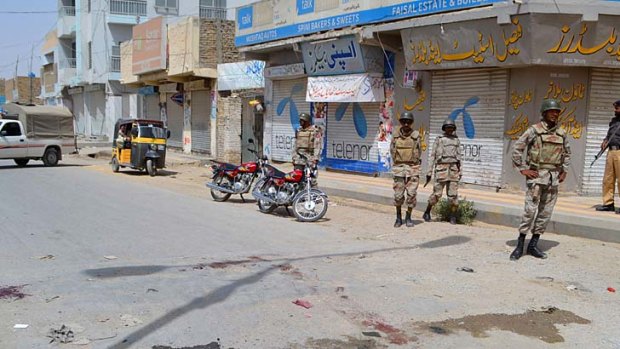 Danger zone ... Pakistani policemen and paramilitary soldiers stand on a street after gunmen shot at two buses in Quetta.