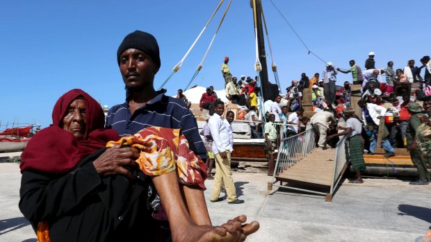 A man carries an elderly woman from a ship fleeing violence in Yemen, at the port of Bosasso in Somalia's Puntland region on Thursday.