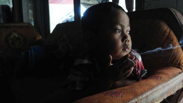 Four-year-old Muhammad Diha Awalidan smokes a cigarette in his parent's house in rural West Java.