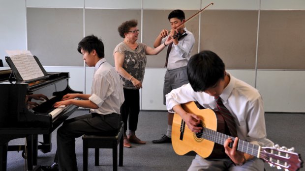 Sour note: Music teacher Zina Berezin at Melbourne High with Sam Xie (piano), Brian Ly (violin) and Ethan Taang.