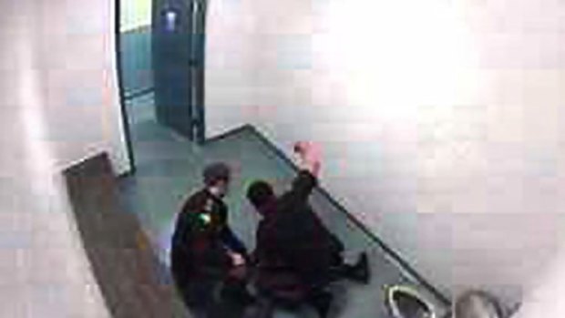 Accused ... a police officer is shown subduing a 15-year-old girl on the floor of a jail cell.