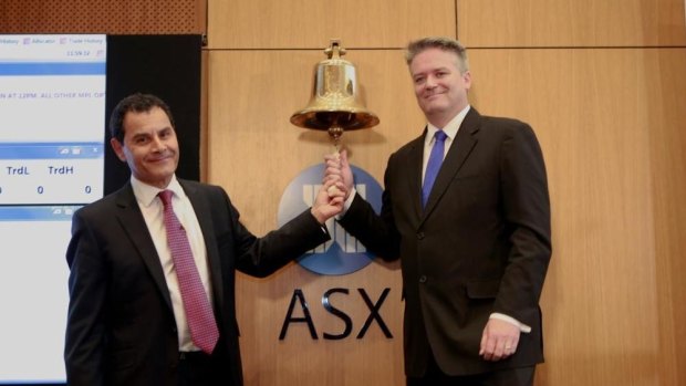 Medibank chief George Savvides and Finance Minister Mathias Cormann ring the bell to send Medibank Private live. 