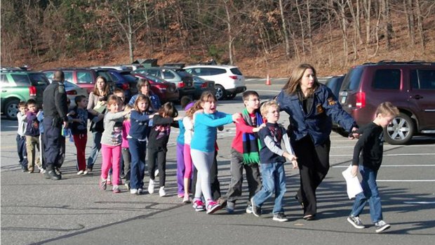 State police personnel lead children from the Sandy Hook Elementary School four years ago.