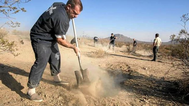 The workers fill the two shallow graves at the site on the outskirts of Victorville that contained the skeletal remains of members of missing McStay family.