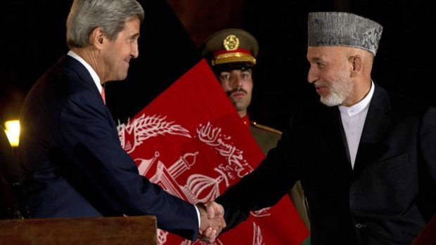 Agreement: John Kerry and Hamid Karzai shake hands after a news conference at the Presidential Palace in Kabul.