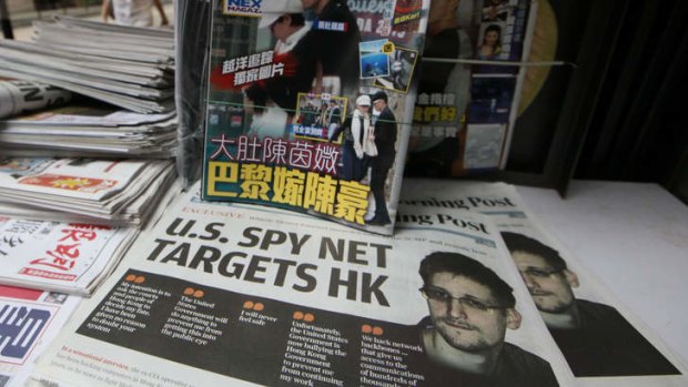 The picture of Edward Snowden, bottom, former CIA employee who leaked top-secret documents about sweeping US surveillance programs, is displayed on the front page of South China Morning Post at a news stand in Hong Kong Thursday, June 13, 2013.