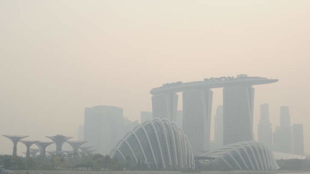 Under siege: The Singapore skyline is shrouded in haze last month as pollution soared to record levels.