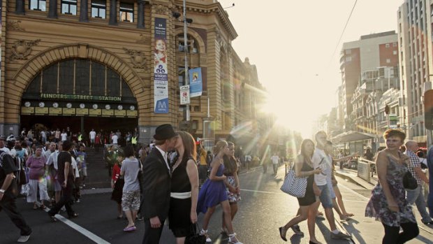 Outside Flinders Street Station, a couple share a kiss in an early start to a happy new  year.