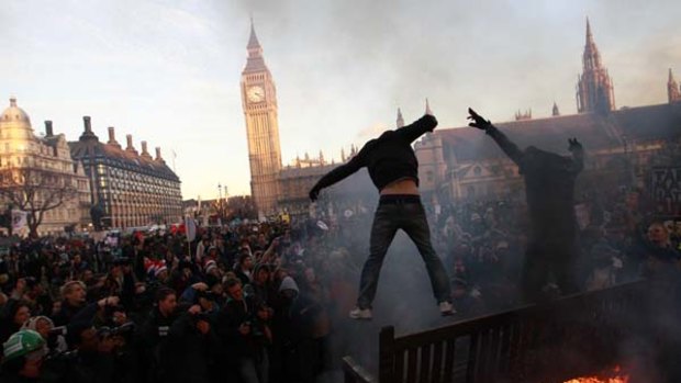 Protest movement ... demonstrators jump off burning park benches outside the Houses of Parliament in Westminster.