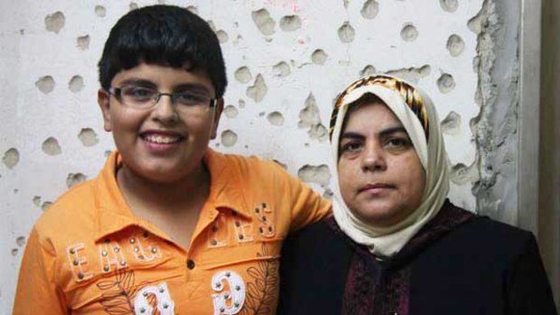 Majed Rabah with his mother Afab Rabah outside their apartment building in Tal Hawah.