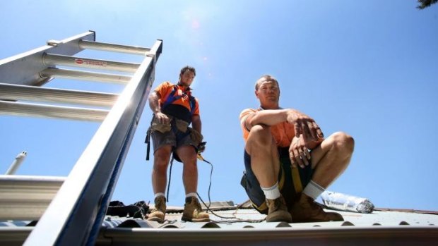 High risk: One of the most dangerous and uncomfortable jobs to do on a scorching hot day - installing metal roofing.