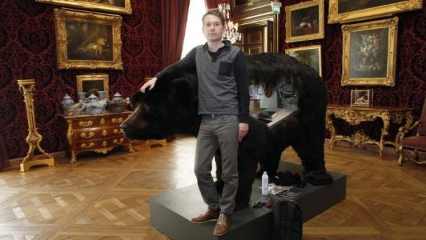 French artist Abraham Poincheval poses for a photograph next to the bear carcass on March 31, the day before starting a 13-day artistic performance at the Hunting and Wildlife Museum in Paris.