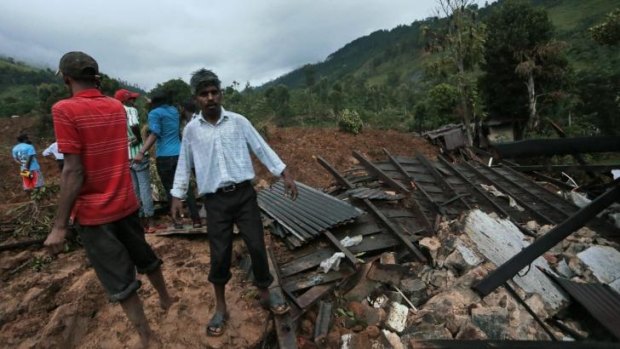 Sri Lankans sift through the rubble at the site of the landslide.