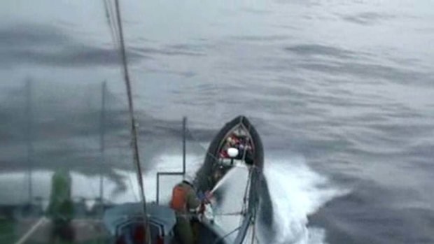 Japanese whalers from the Yushin Maru No.3 employ water cannon against Sea Shepherd activists in small boats.