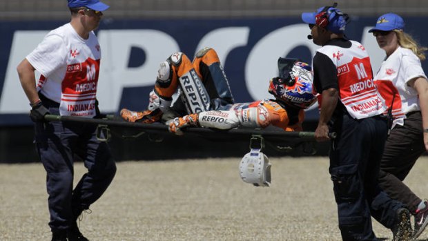 Casey Stoner, of Australia, is carried off my medical personnel after he crashed during the qualifying session for the MotoGP motorcycle race at the Indianapolis Motor Speedway.