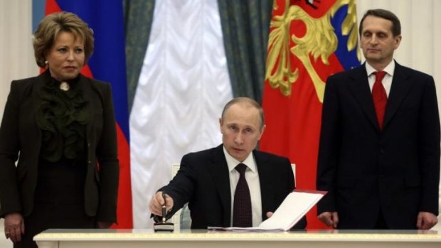 Expanding Russia ... President Vladimir Putin signs legislation on Friday that completed the process of absorbing Crimea into Russia, defying Western leaders who say the Black Sea peninsula remains part of Ukraine. 