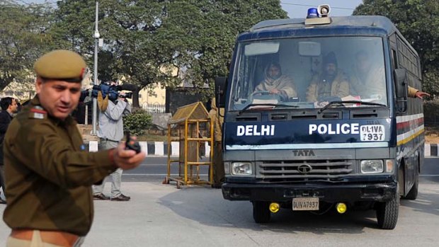 In this photograph taken on January 7, 2013, Indian police personnel guide a vehicle, which is believed to be carrying the accused.