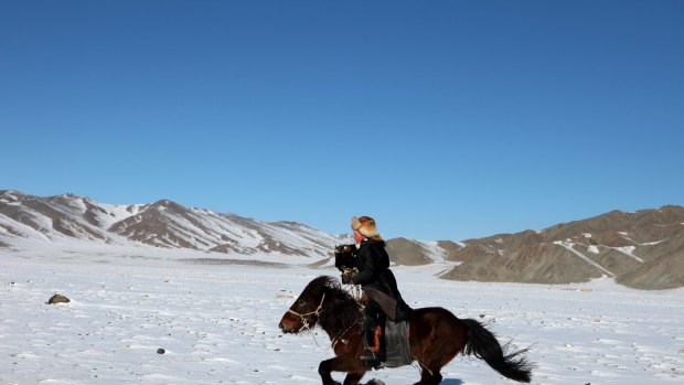 Aisholpan hunting for foxes in the Altai mountains.