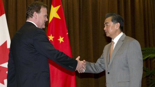 Canada's Foreign Minister John Baird (left) shakes hands with Chinese Foreign Minister Wang Yi before a meeting at the Foreign Ministry in Beijing.