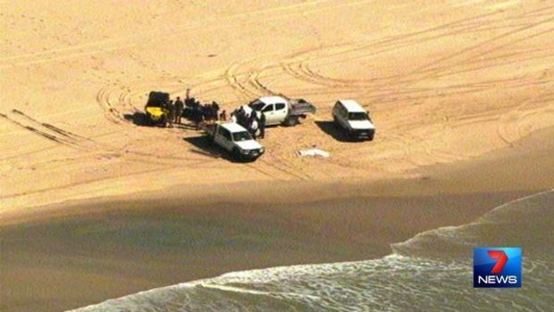 Police at the scene where a man's body washed up on South Stradbroke Island.