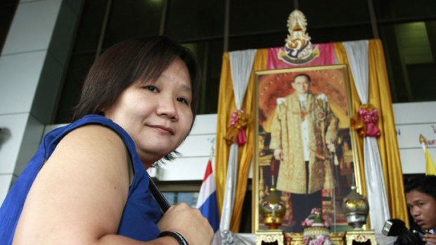 Chiranuch Premchaiporn, director of Prachatai website, walks past a portrait of King Bhumibol Adulyadej at the criminal court in Bangkok, Thailand. A Thai court sentenced Chiranuch to an eight-month suspended sentence for failing to act quickly enough to remove Internet posts deemed insluting to Thailand's royalty.