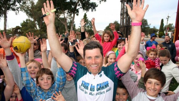 Merredin residents lined the streets to welcome footy legend Shane Crawford as he rode into town.