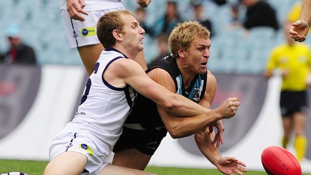 Just too fast: Fremantle's David Mundy adds to Port Adelaide's trauma by stopping a Kane Cornes handball.