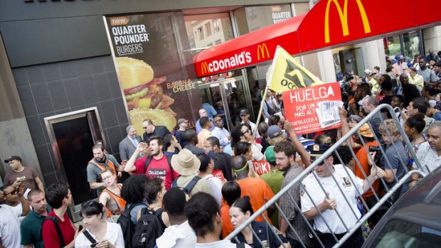 Demonstrators in support of fast food workers protest outside a McDonald's as they demand higher wages and the right to form a union without retaliation.