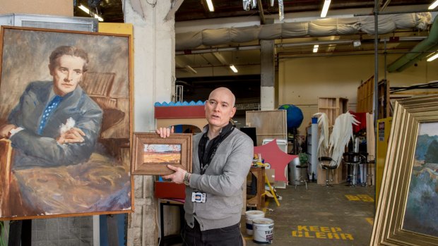 Veteran set buyer-dresser Andrew Best with one of the many paintings created by the props department backstage at the ABC's TV studios in Elsternwick.