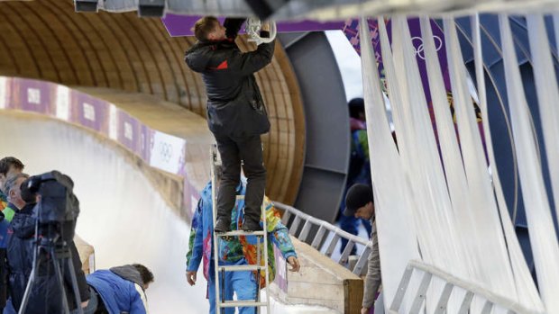 Sudden impact: A track worker repairs some lights that were damaged after a worker was hit by a forerunner bobsleigh.