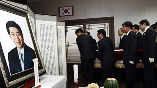 Troubling questions...  friends and family carry Mr Roh's coffin to a memorial at his home.