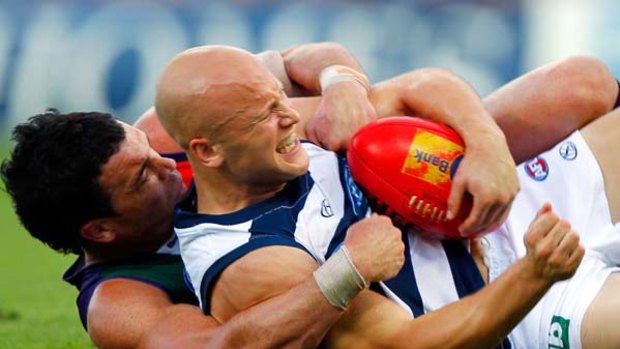 Cat star Gary Ablett is collared in a tackle by Docker Ryan Crowley during Fremantle's thrilling win at Subiaco Oval yesterday.