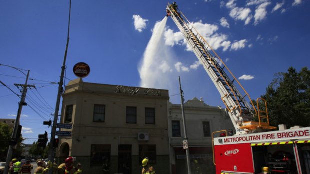 Firefighters battle a blaze at Carlton bookshop Book Affair, on the corner of Lygon and Elgin streets.
