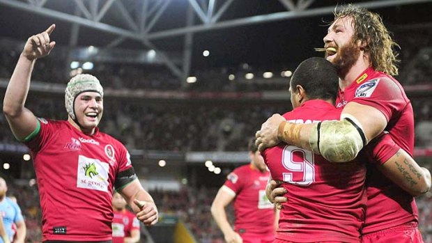 Will Genia, Scott Higginbotham (right) and Liam Gill (left) celebrate as the Reds blast into the Super Rugby finals.