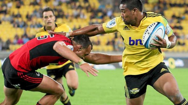 Julian Savea of the Hurricanes fends off Israel Dagg of the Crusaders.