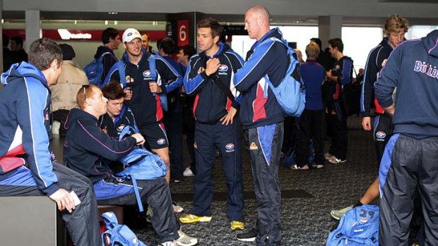 Western Bulldogs players wait for their flight to Brisbane yesterday.