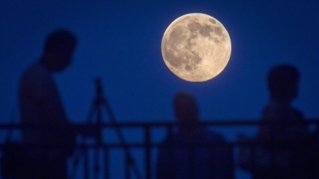 People watch the supermoon from a bridge in New York.