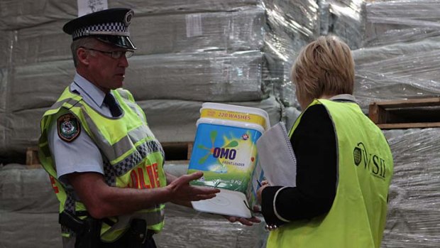 Police examine powder and OMO buckets they believe to be part of a counterfeit organisation.