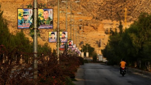 Overrun: Posters of dozens of Hezbollah fighters killed fighting in Syria against IS line the road entering Hermel village in the Bekaa Valley, Lebanon.