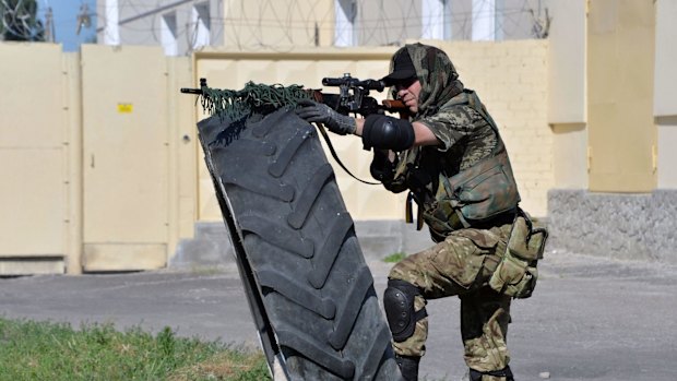 A member of the pro-Ukraine Donbass Battalion stands in firing position during a patrol in the outskirts of the eastern Ukrainian city of Lysychansk, which Ukraine forces have taken off the rebels.