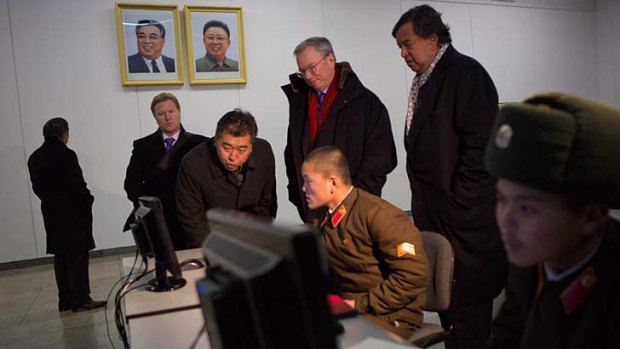 Executive chairman of Google, Eric Schmidt, back row left, and former Governor of New Mexico Bill Richardson, back row right, watch North Korean soldiers working on computers.