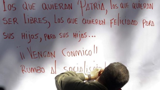 The style will live on: late Venezuelan President Hugo Chavez writes a message after signing his support for a proposal to change the constitution, in Caracas in December 2008.
