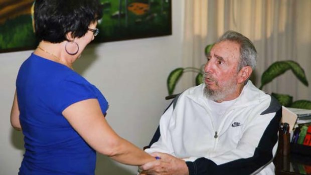 Former Cuban leader Fidel Castro greets a worker of the National Centre for Scientific Investigation in Havana.